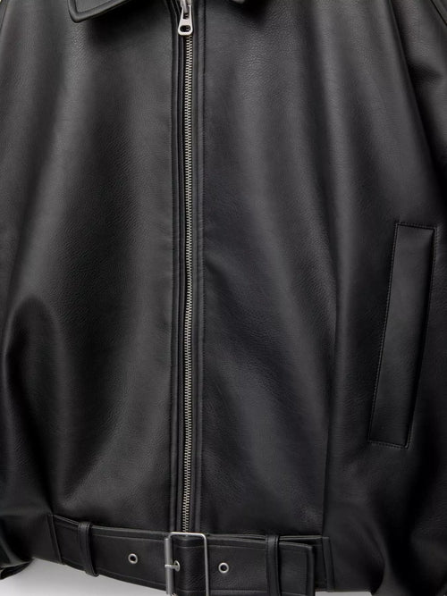 Close-up of a black leather jacket with a front zipper, side pocket, and matching black belt with silver buckle.