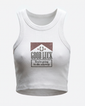 A white ribbed tank top with a graphic print on the front. The graphic features a distressed brown and black design with a horseshoe and the text 'GOOD LUCK You're going to die anyway'.