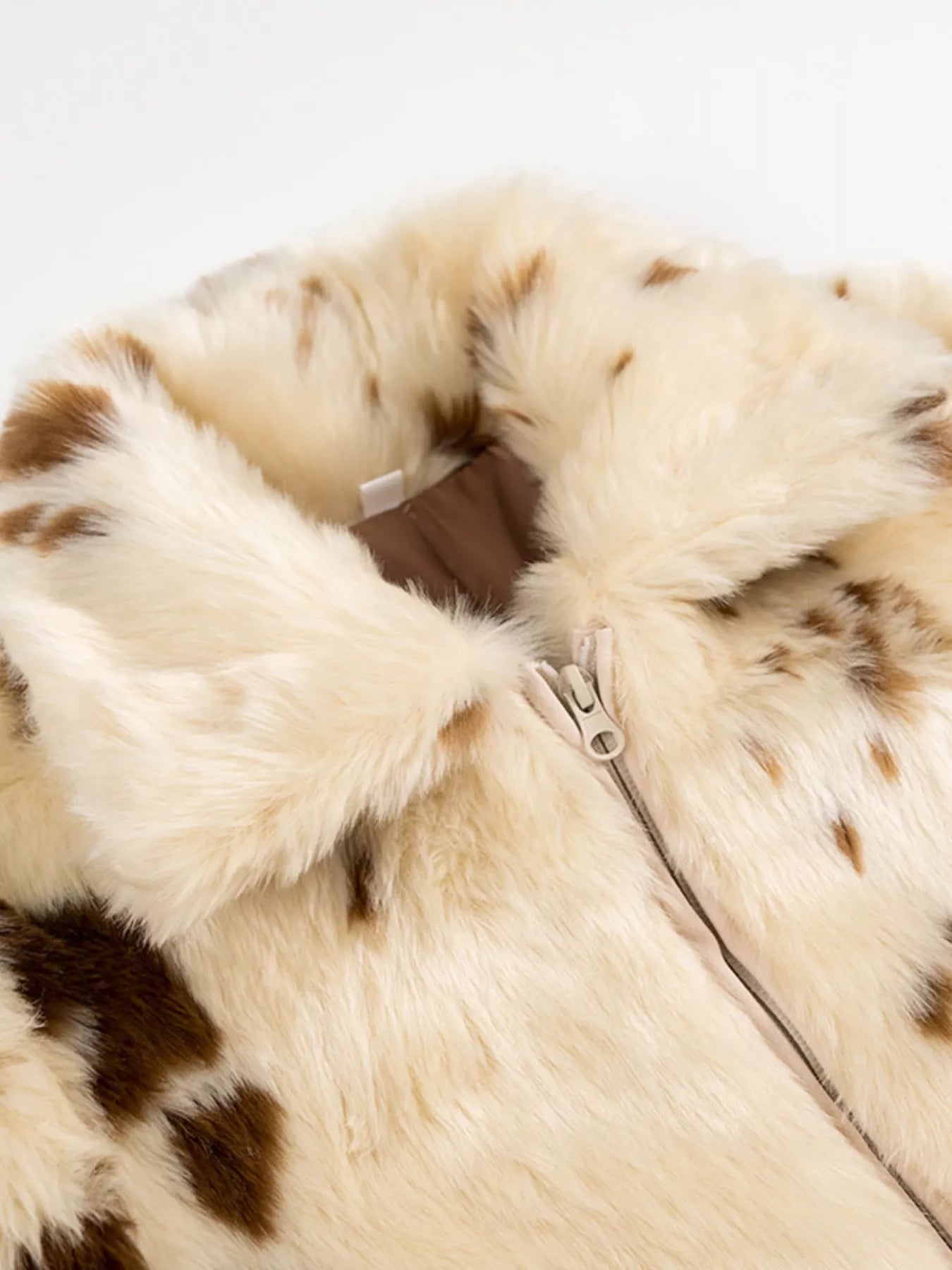 Close-up of a fur coat with a zipper on a light gray background