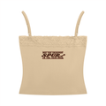 A beige camisole crop top with thin shoulder straps, a lace-trimmed neckline, and a dark brown printed text graphic on the chest reading 'NOT THE SHARPEST SPUR IN THE TACK ROOM'.