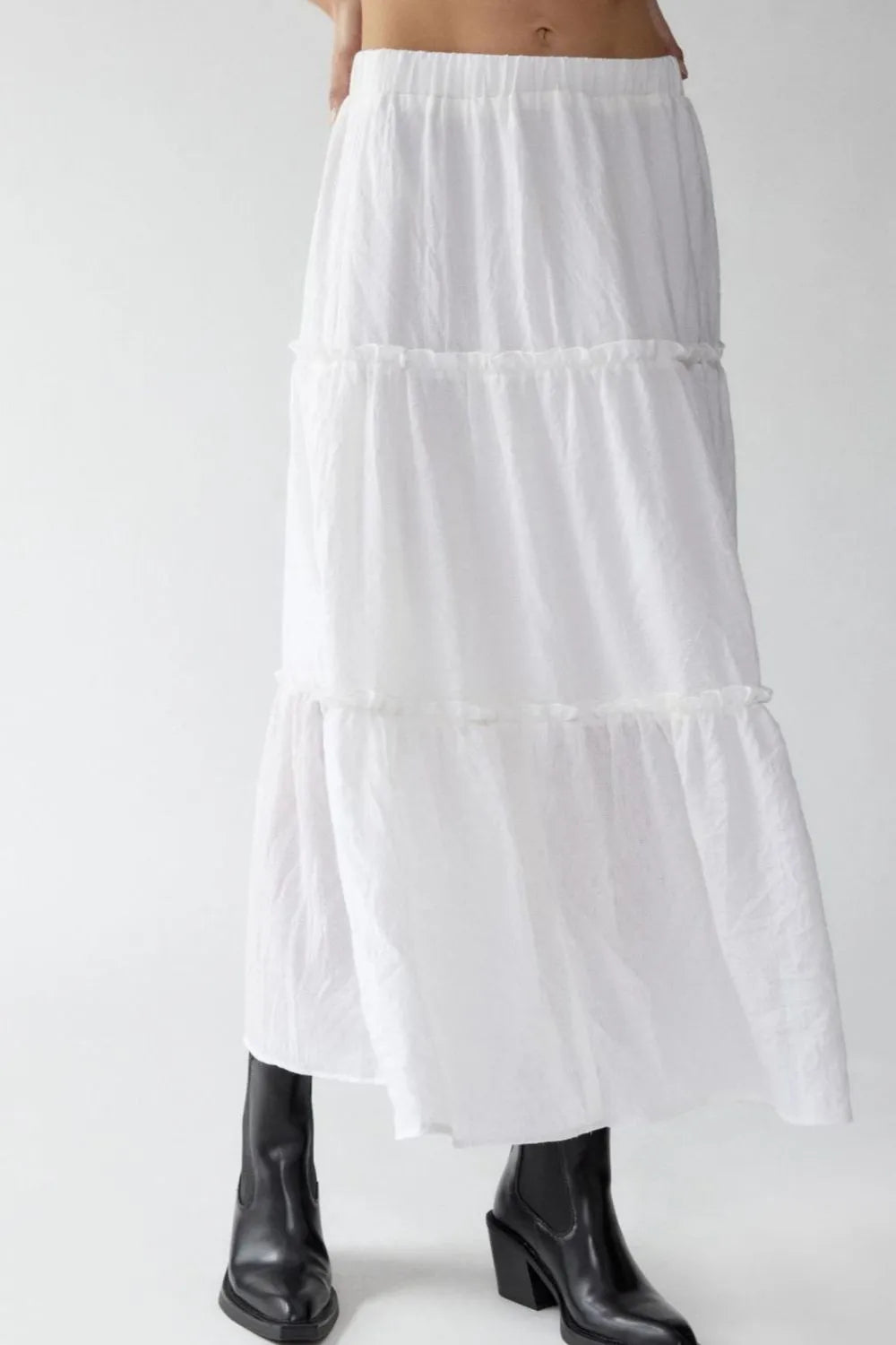 White tiered skirt worn by a person on a white background