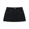 A black denim mini skirt with gold-tone metal studs and a button closure, displayed flat against a solid white background.